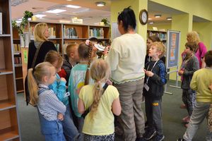 Grupa dzieci w trakcie rozwiązywania zagadek w czytelni Biblioteki Głównej
