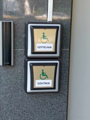 Przyciski przeznaczone dla osób z niepełnosprawnością przy drzwiach wejściowych prowadzących z parkingu do Biblioteki Głównej