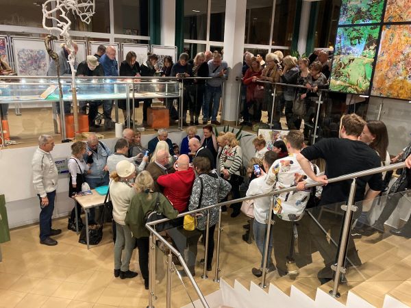 Duża grupa gości wernisażu stojących na schodach i na galerii podczas happeningu Andrzeja Buko