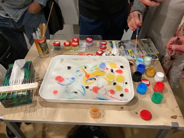 Stolik z farbami i kuwetą służącą do malowania techniką ebru