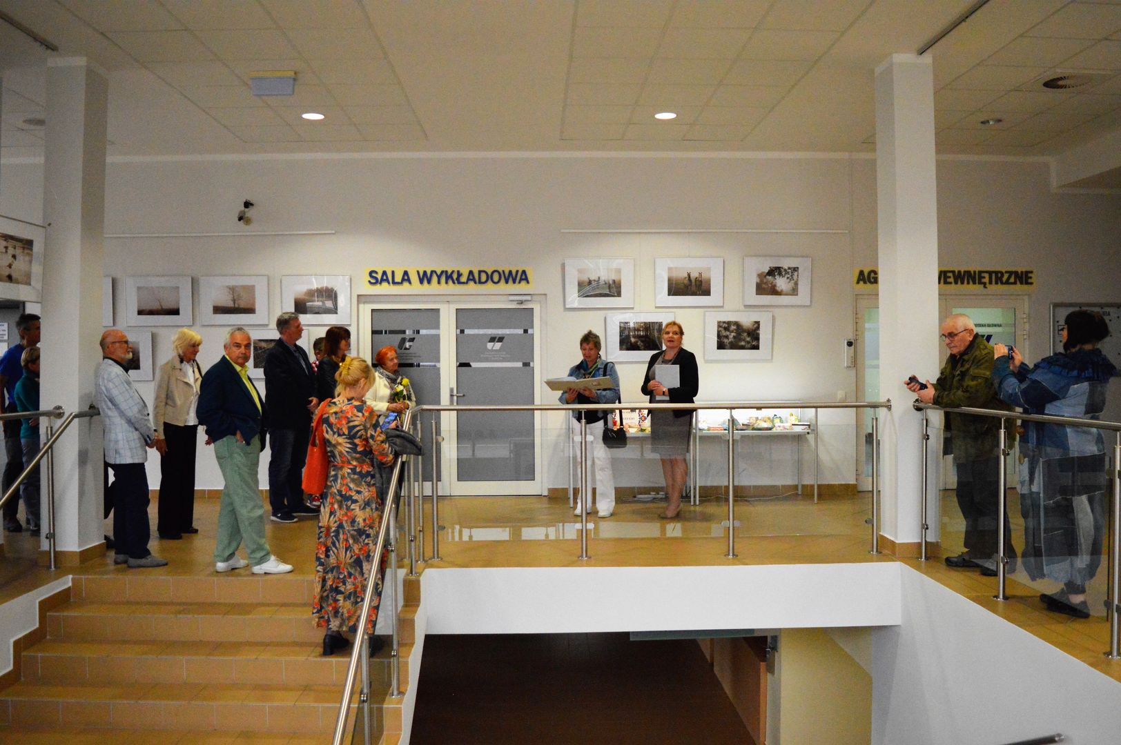 Danuta Borek w towarzystwie dyrektor Anny Gryty opowiada o swojej wystawie fotografii gościom zebranym na wernisażu