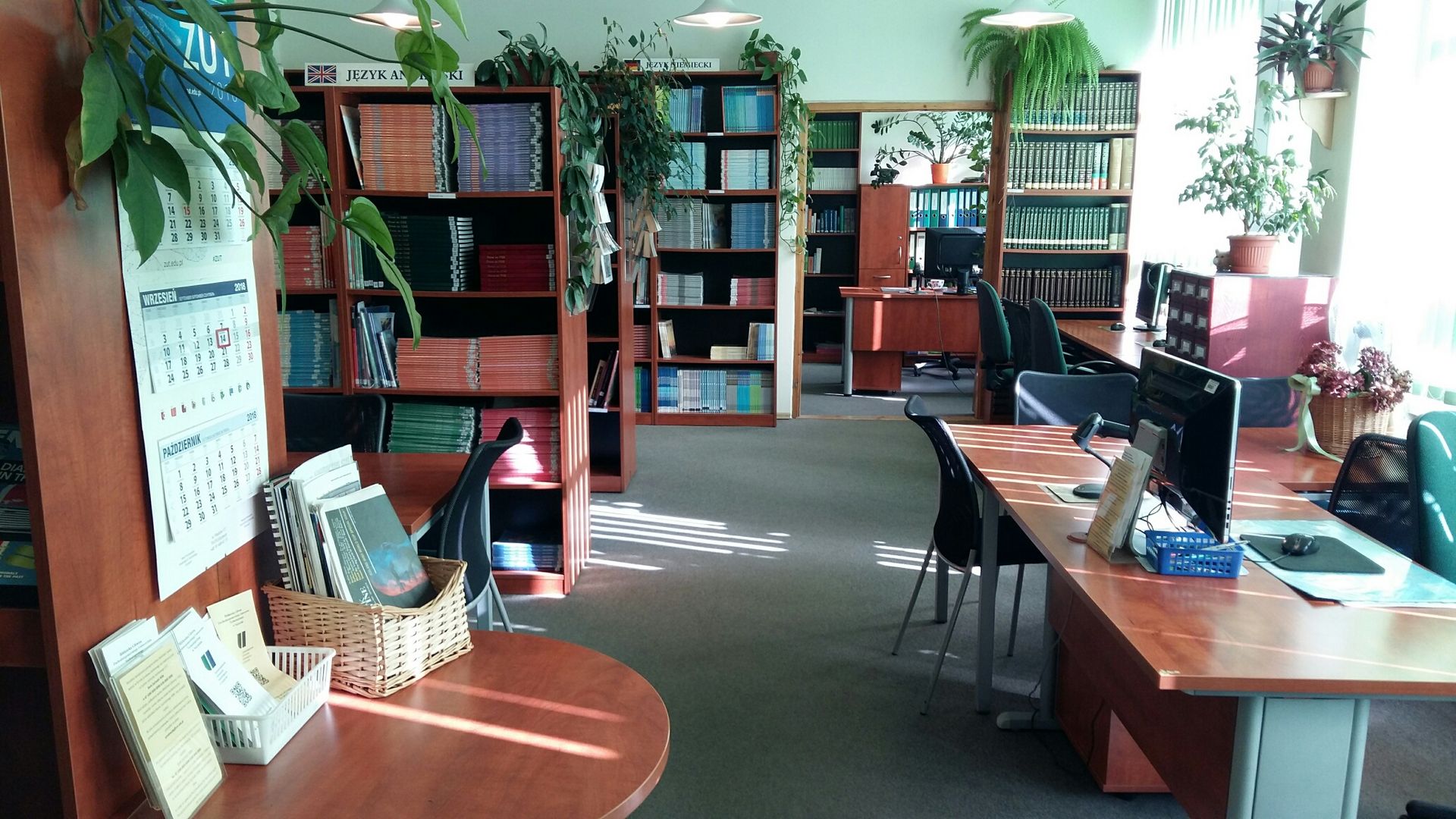 Widok na stanowiska bibliotekarzy oraz regały w Wypożyczalni Językowej