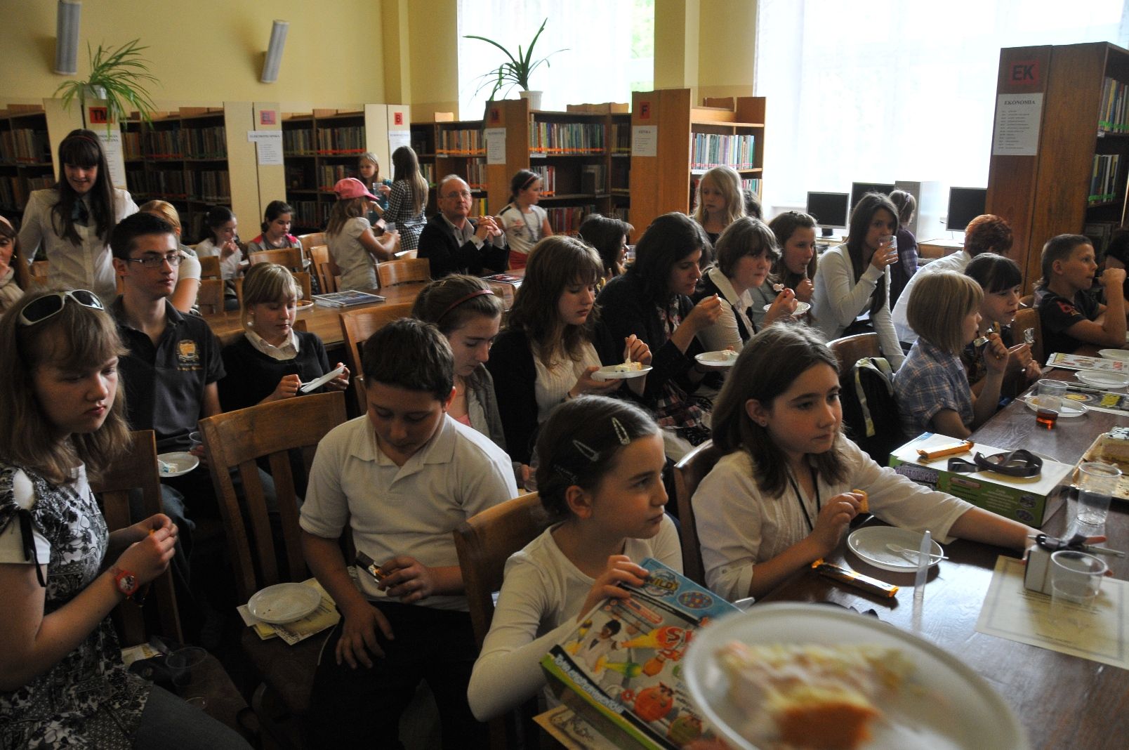 Pomieszczenie Biblioteki Wydziału Technologii i Inżynierii Chemicznej wypełnione uczestnikami konkursu jedzącymi okolicznościowy tort
